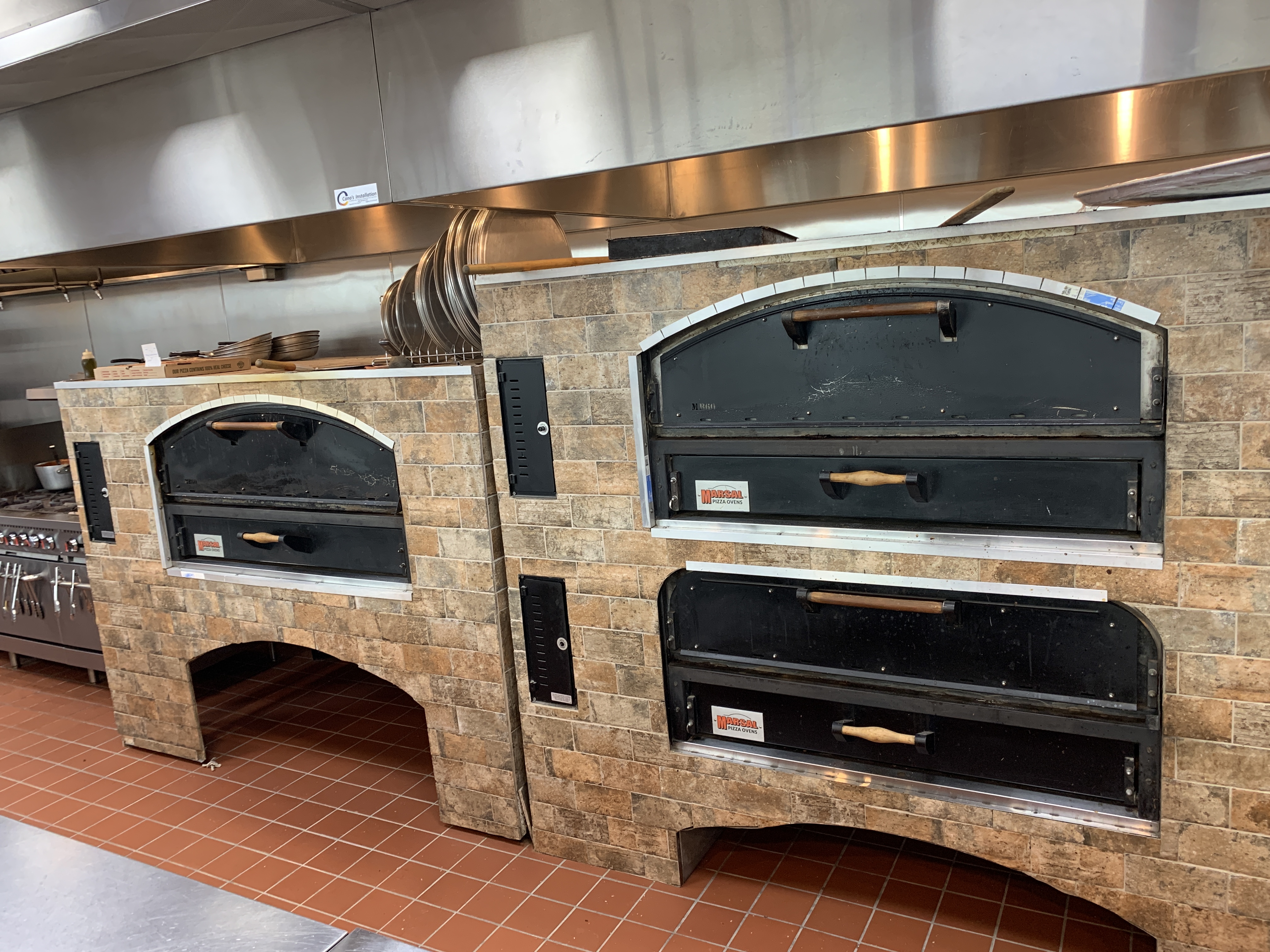 Wood-fired brick pizza ovens baking New York-style pizza at Jonny's Pizza in Frisco, TX