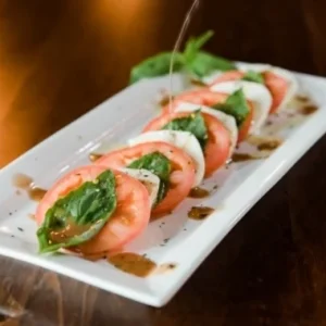 Caprese salad with tomato, mozzarella, and basil at Jonny's Pizza in Aubrey and Frisco, TX