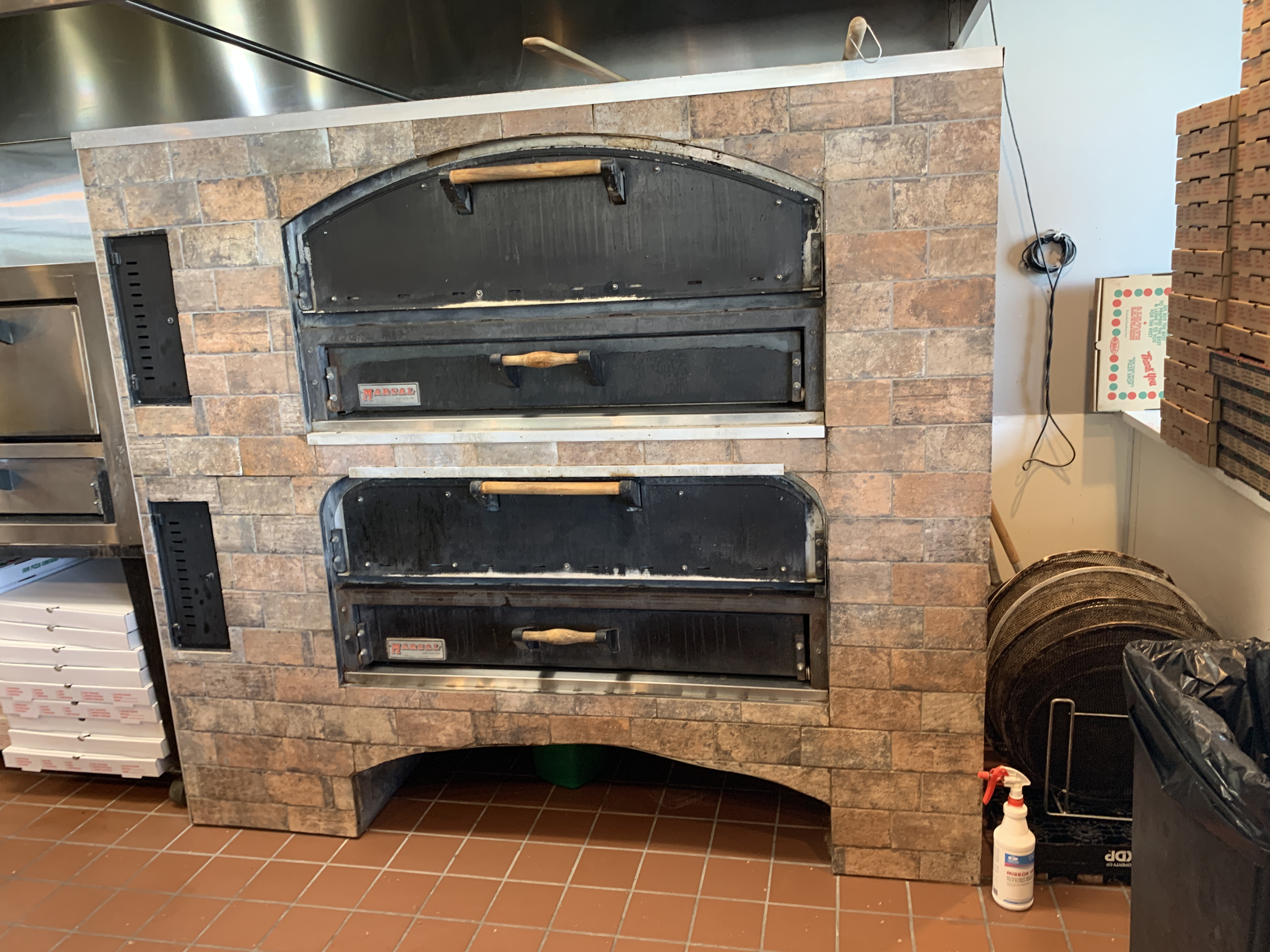 Double-deck brick pizza oven baking New York-style pizza at Jonny's Pizza in Aubrey, TX